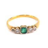 An Art Deco style dress ring, baguette cut with central emerald flanked by two small diamonds on an