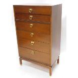 A G-Plan teak narrow chest, of six graduated drawers, each with brass ring handles on shaped stand w