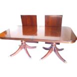 A mahogany extending dining table in Regency style, the rectangular top with rounded corners on turn