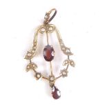 An Edwardian 9ct gold drop pendant, set with pearls and claw set with a central garnet, with further