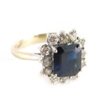 A 18ct white gold dress ring, claw set with central sapphire, florally surrounded by small claw set