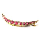 A 9ct gold crescent brooch, in the Edwardian style set with fifteen red paste stones.