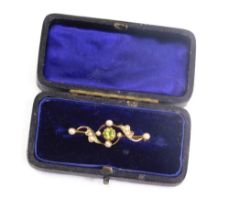 An Edwardian peridot and pearl brooch, with entwined decoration and plain back, 3cm long. (cased)