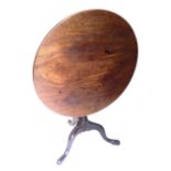 A George III mahogany tilt top table, with a circular top, on a turned column and tripod base with p
