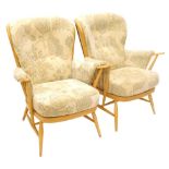 A pair of Ercol light beech spindle back armchairs, with padded backs, arm rests and seats, design n