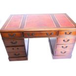 A mahogany pedestal desk, the rectangular top with a red leather insert above an arrangement of nine