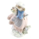 A Lladro figure of a girl holding basket, number 5221, marked beneath, 19cm high.