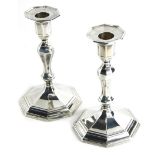 A pair of George V silver candlesticks, with baluster stems and octagonal bases, loaded London 1922,