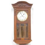 A 20thC oak wall clock, the 18cm diameter chrome plated face, with Arabic numerals, in a carved case