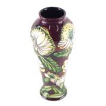 A Moorcroft pottery vase by S Hayes, decorated with flowers on red ground, marked beneath, 27cm high