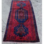A heavy pile red and blue Persian Nahavan rug, in vintage medallion design, 215cm x 100cm.