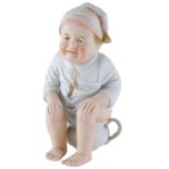 An early 20thC bisque porcelain figure of a child, seated on chamber pot, 19cm high.