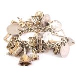 A silver charm bracelet, set with many silver and white metal charms, coin, bell 1cm high, elephant,