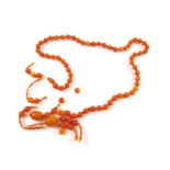 An amber style necklace, with uniform beads and a quantity of other polished amber coloured beads, e