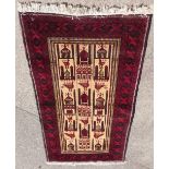 A Persian prayer rug, with a design of buildings, birds, etc. in deep red on a cream ground with mul