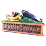 A metal articulated Jonah and the Whale money bank, 25cm wide.