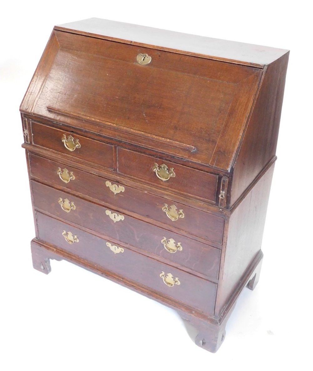 An 18thC oak bureau, the fall enclosing a fitted interior above two short and three long drawers, ea