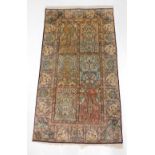 A Persian silk rug, with a design of flowers, leaves, etc., within compartments, 163cm x 94cm.