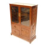 A Chinese hardwood side cabinet, with a panelled top over two glazed doors and two carved drawers an
