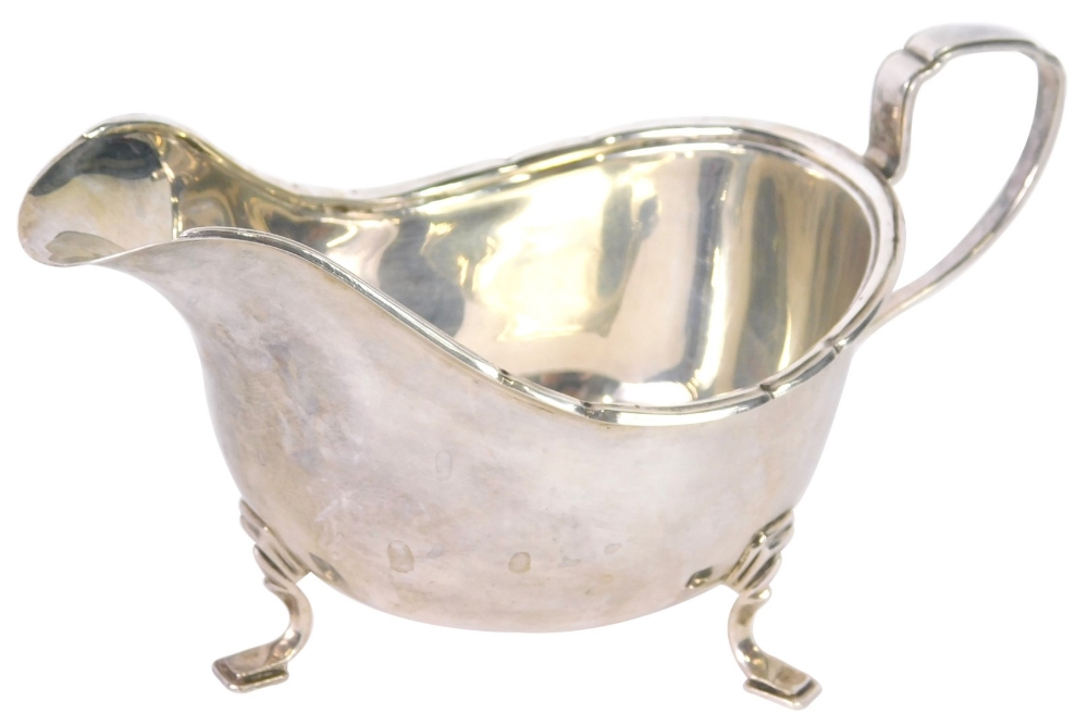 A George VI silver sauce boat, by Walker and Hall, of cape form on stepped feet with angular handle,