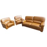 A tan coloured leather three piece suite, with cream stitching, comprising sofa and two armchairs, t