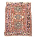 A Karaja rug, with three geometric medallions in blue, beige and green, on a red ground with one wid