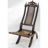 A Victorian walnut and caned folding side chair, with spirally turned supports and shaped crest.