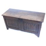 A late 18th/early 19thC oak coffer, with a two planked top above a panel front with fluted carving,