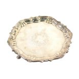 A George II silver waiter, by Robert Abercromby, with scroll and shell border, on triple hoof feet,