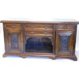 An early 20thC oak sideboard, the top with a moulded edge above an arrangement of four drawers, each