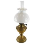 A brass oil lamp, with milk glass shade, clear reservoir and brass stem, 47cm high. (AF)