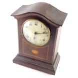 An Edwardian mahogany mantel clock, the serpentine top raised above a 13cm diameter Arabic case, in