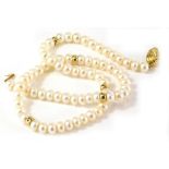 A cultured pearl single strand necklace, with rounded beads, and gold coloured brakes, with oval swi