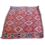 A Persian flat weave Soumak camel bag or Juval, with a design of medallions on a red ground with one