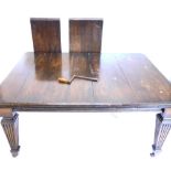 A late 19th/early 20thC oak extending dining table, the rectangular top with canted corners, on squa