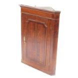 A 19thC oak hanging corner cabinet, with a moulded cornice above a panelled door, 108cm high, 81cm w