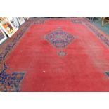 A 20thC Oriental rug, the inner field decorated with a floral arrangement in red and yellow on a blu