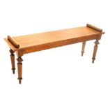 A Victorian oak bench or window seat, with cylindrical arms, on turned tapering legs, 122cm wide.