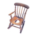 A 19thC child's ash and elm rocking commode Windsor chair, with turned supports, 36cm wide.