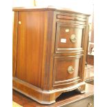 A serpentine mahogany finish pedestal cabinet.