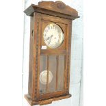An oak wall clock with Arabic dial.