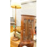 A standard lamp with yellow shade, oak drop leaf dining table, and a corner display cabinet. WARNING