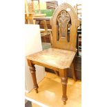 An early 20thC oak hall chair, with pierced back.