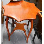 An Edwardian mahogany two tier table, the shaped octagonal top on splayed supports with concave unde