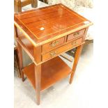 An Edwardian style mahogany finish side table, with two drawers on square tapering legs.