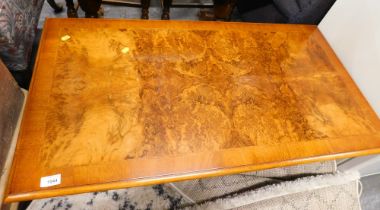 A walnut coffee table, on end supports, 107cm wide.