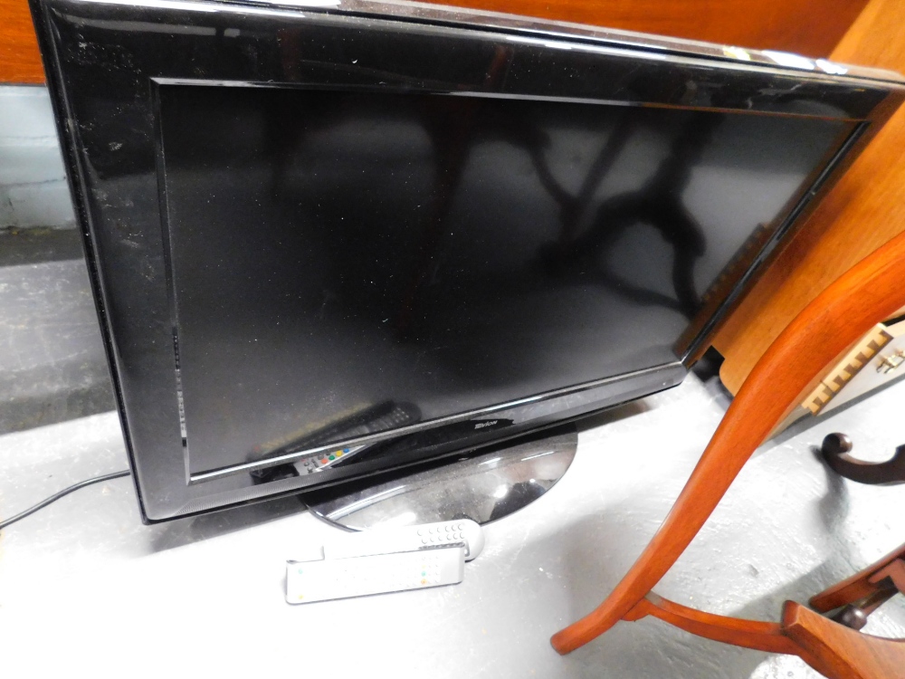 A Tevion 32" flat screen television, in black trim with wire and remote control.