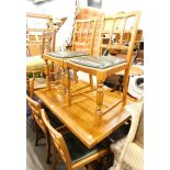 An oak draw leaf dining table, with heavy supports joined by a H stretcher, and six chairs.