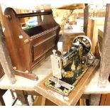 A walnut cased Jones sewing machine, and a newspaper rack.