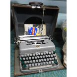 A vintage Imperial typewriter in grey, with Royal Crest and outer case.